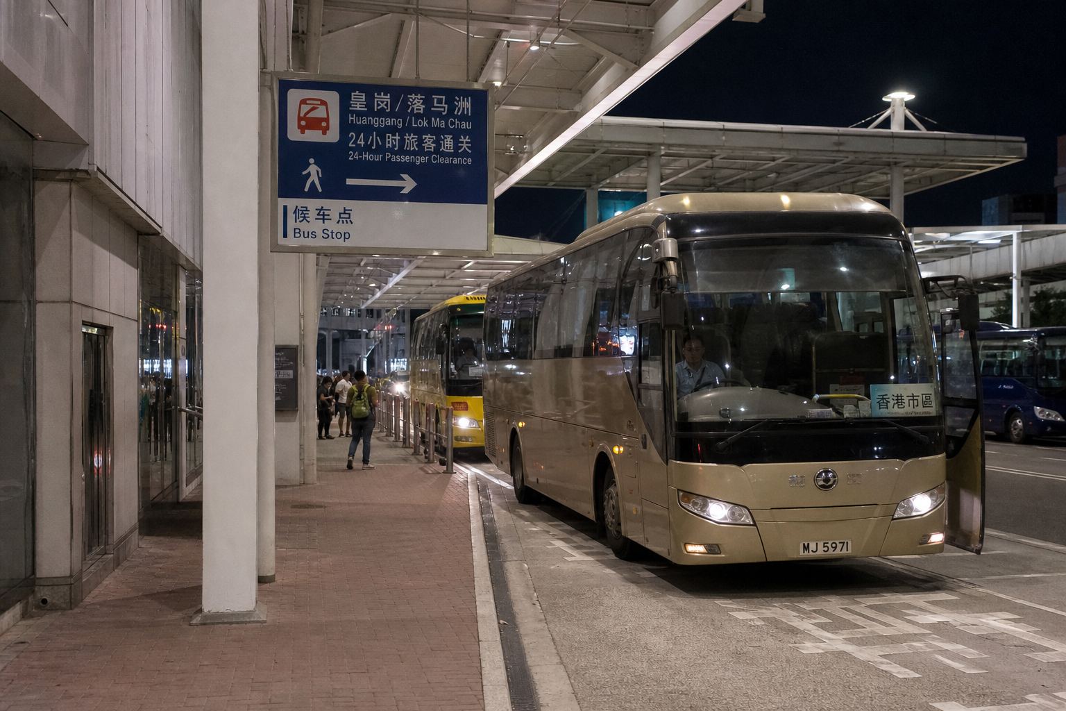 The Huanggang road crossing at night, coaches at a 24-hour stop.