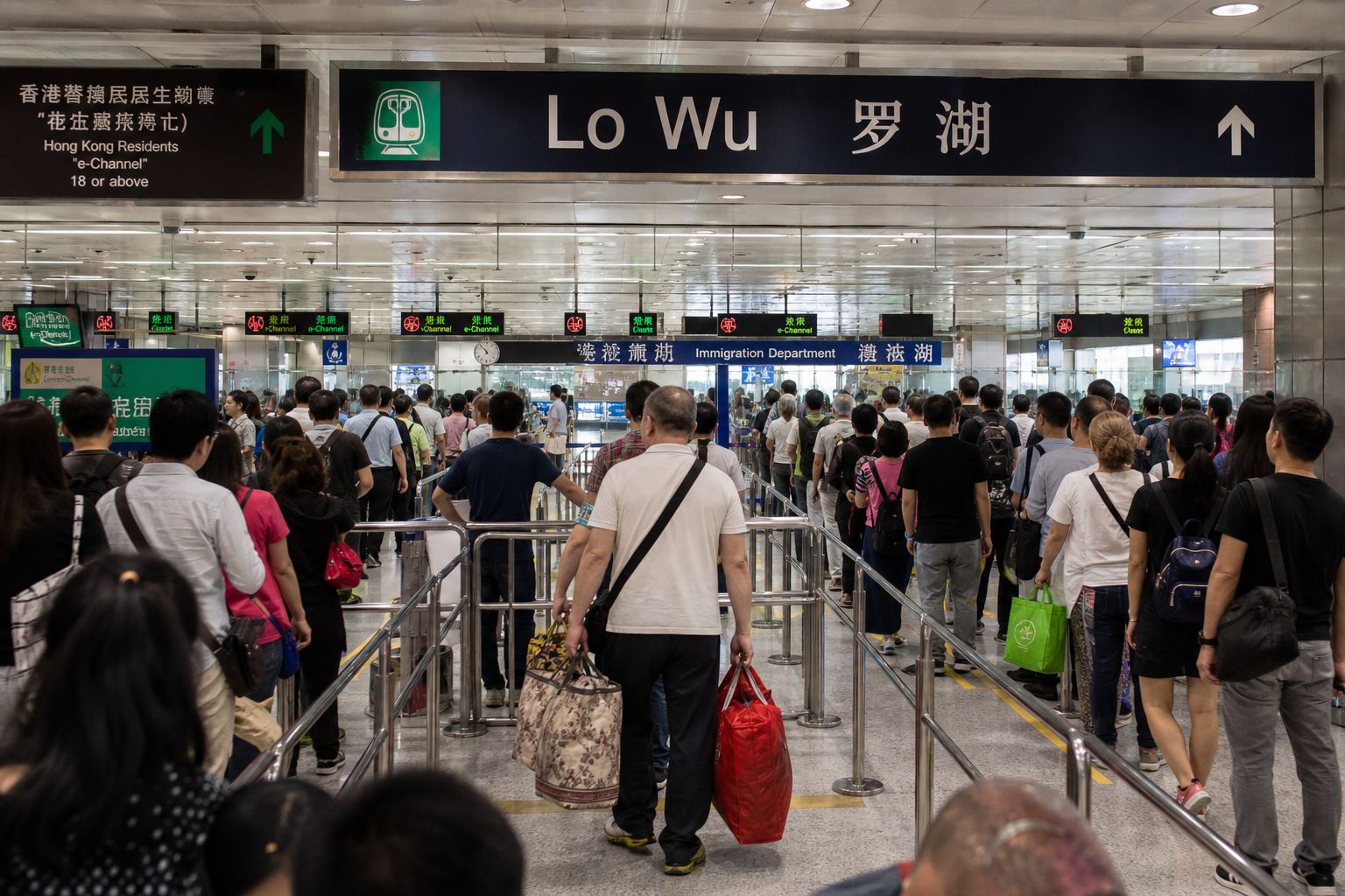Lo Wu / 罗湖 signs above a busy border hall.