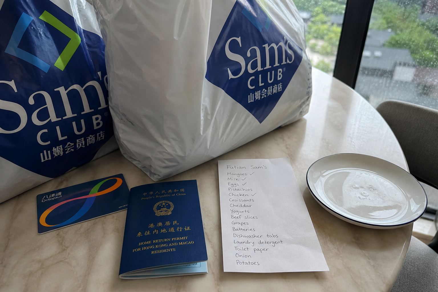 Sam's bags, an Octopus card, and a Home Return Permit on a kitchen table.